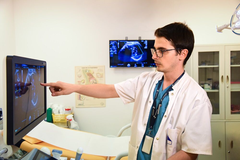 Dr. Cătălin Herghelegiu arată pe monitor o ecografie de sarcină, la SANADOR.