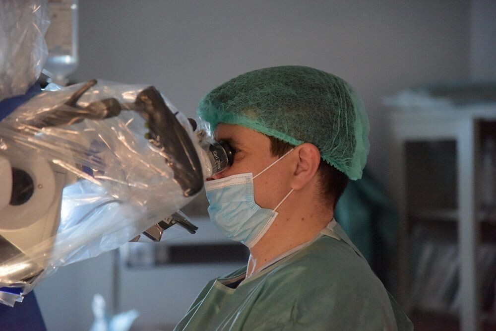 Dr. Dan Benția la microscop operator, în timpul unei intervenții neurochirurgicale la Spitalul Clinic SANADOR.